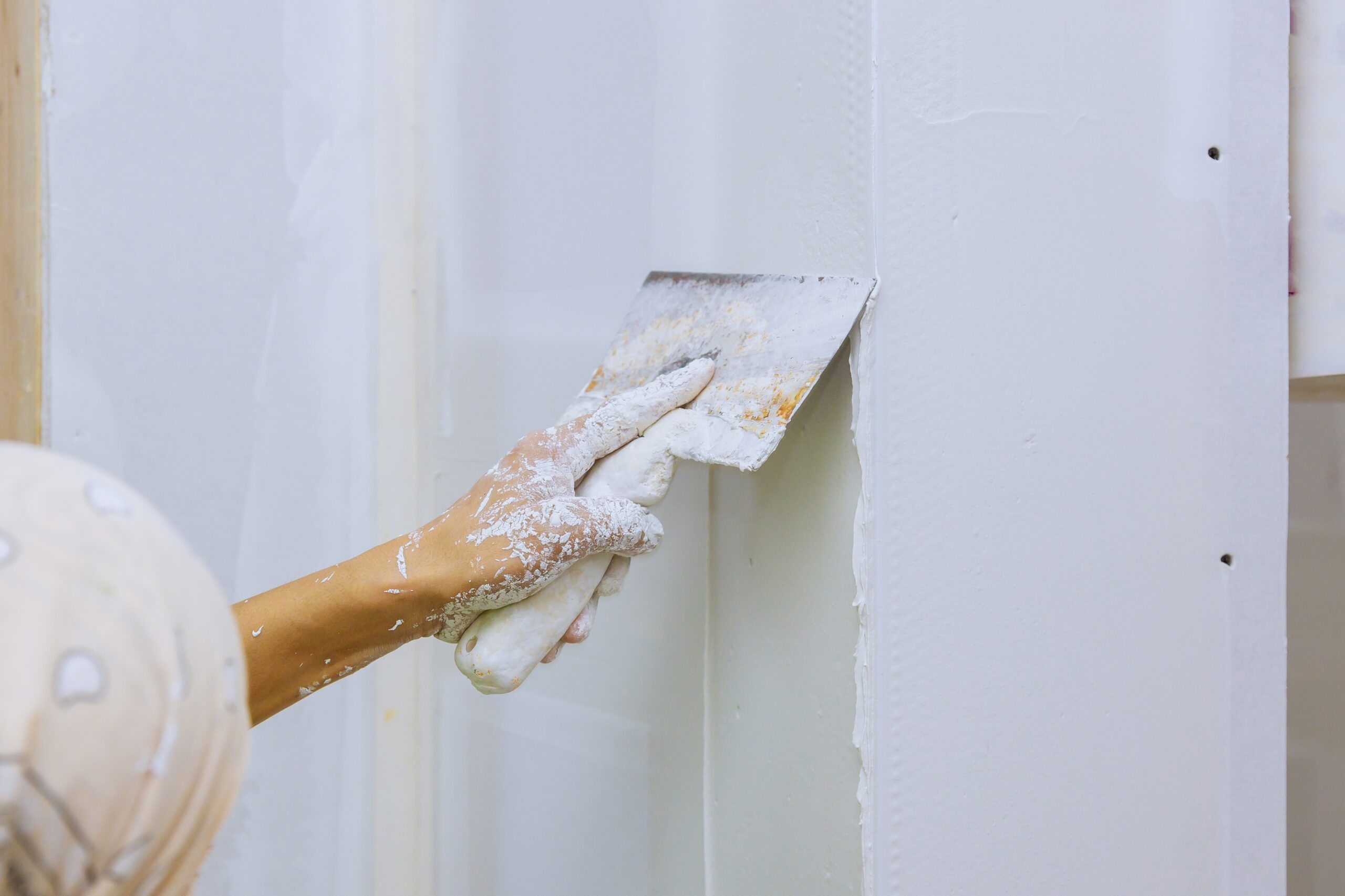 Stucwerk aanbrengen op een muur met een spatel